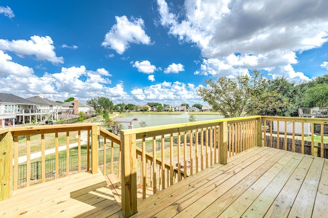 wooden deck featuring a residential view and a water view