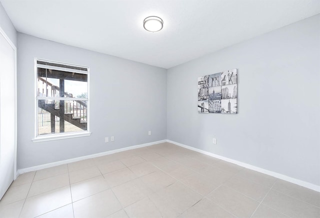 spare room with light tile patterned floors and baseboards