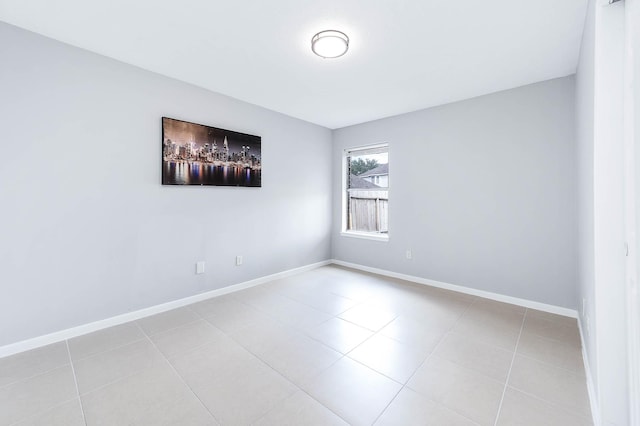 unfurnished room featuring baseboards and light tile patterned floors