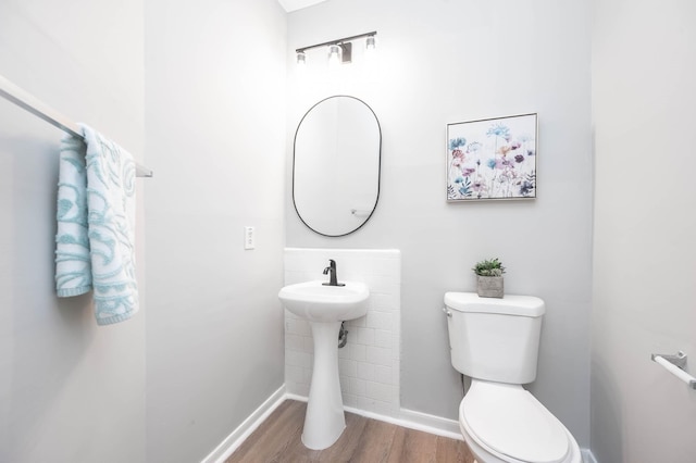 bathroom featuring baseboards, toilet, and wood finished floors