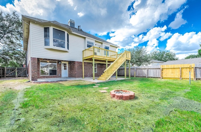 rear view of property with brick siding, stairway, an outdoor fire pit, a fenced backyard, and a wooden deck