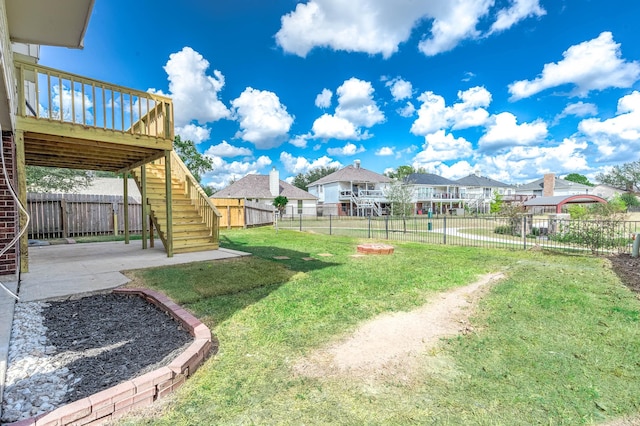 view of yard with a residential view, a fenced backyard, a patio, and stairway