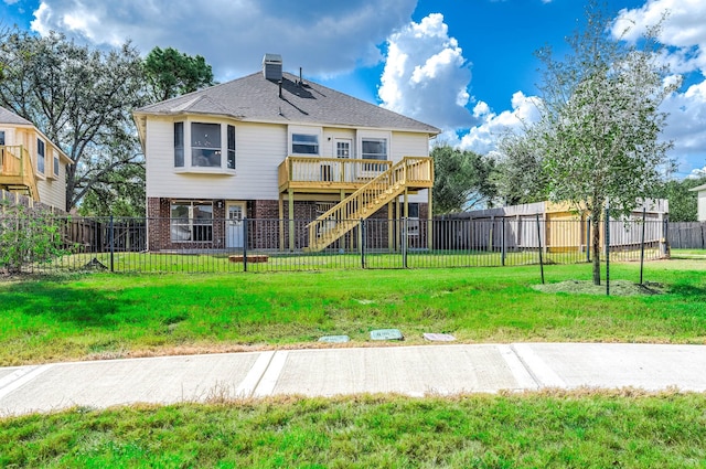 rear view of house featuring a deck, a fenced backyard, brick siding, a lawn, and stairway