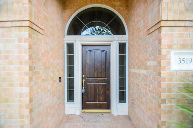 doorway to property featuring brick siding