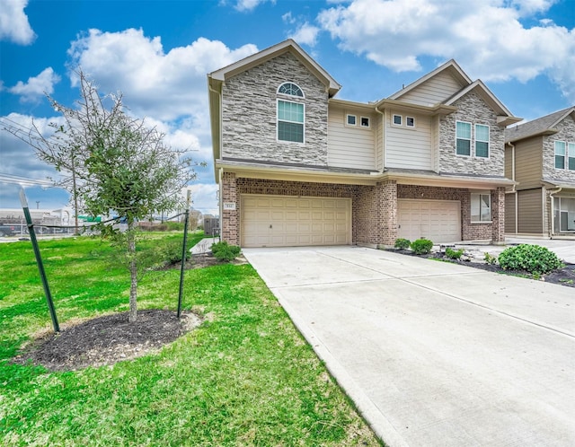 view of front of house featuring a front yard, an attached garage, concrete driveway, and stone siding