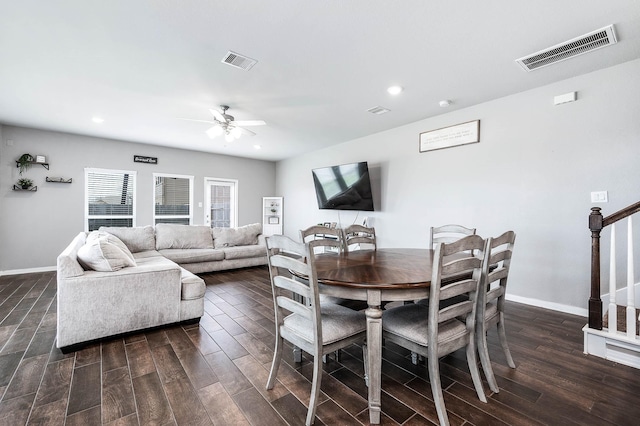 dining room featuring visible vents, baseboards, dark wood-type flooring, and stairs