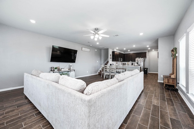 living area with wood finish floors, visible vents, recessed lighting, baseboards, and stairs