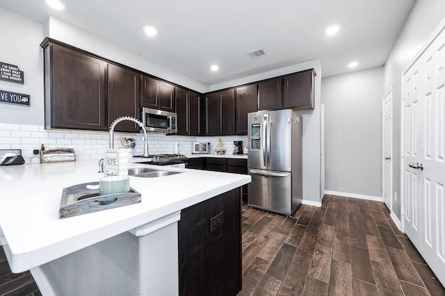 kitchen featuring visible vents, tasteful backsplash, stainless steel appliances, light countertops, and dark brown cabinets