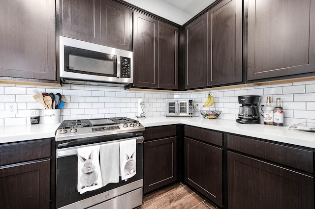 kitchen featuring decorative backsplash, dark brown cabinets, stainless steel appliances, and light countertops