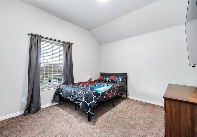 bedroom with carpet flooring, baseboards, and vaulted ceiling