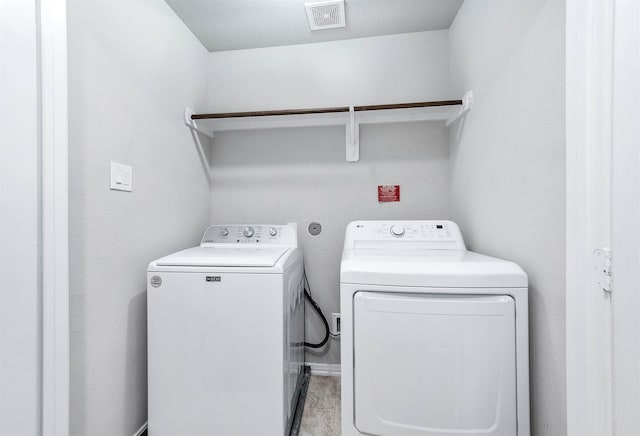 laundry area featuring laundry area, washing machine and dryer, and visible vents