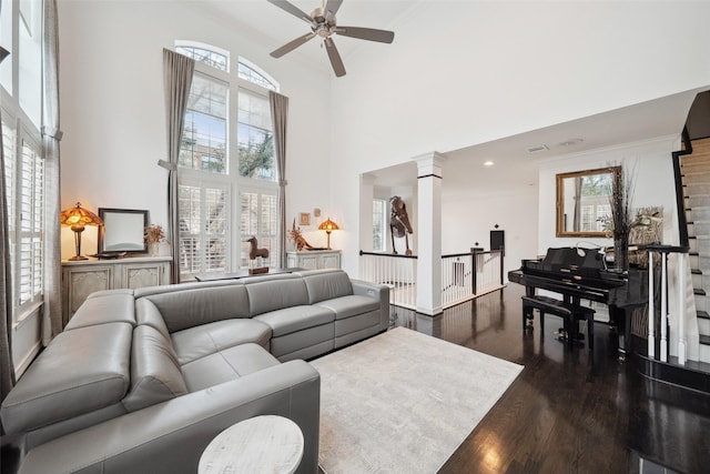 living room with a wealth of natural light, dark wood-style flooring, a high ceiling, and a ceiling fan