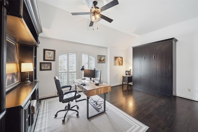 home office with baseboards, a ceiling fan, dark wood-style flooring, and vaulted ceiling