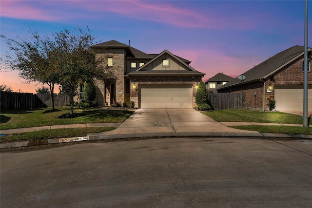 view of front facade with concrete driveway, stone siding, fence, a front yard, and brick siding