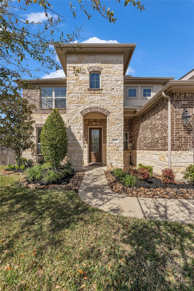 view of front facade with a front lawn and stone siding