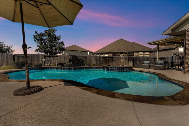 view of swimming pool with a patio, a fenced backyard, and a pool with connected hot tub