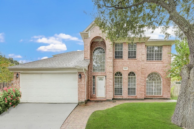 view of front of house with an attached garage, brick siding, fence, concrete driveway, and a front lawn