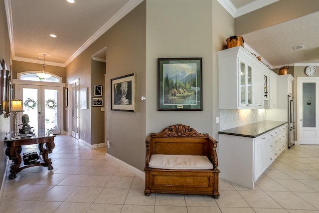 interior space featuring french doors, visible vents, crown molding, and light tile patterned floors