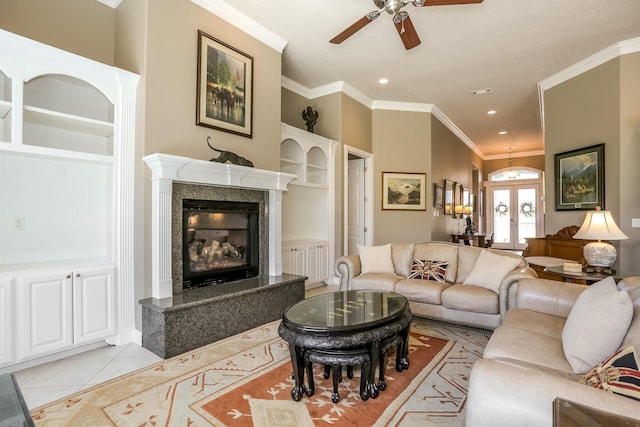 living area featuring light tile patterned floors, crown molding, french doors, built in shelves, and a fireplace