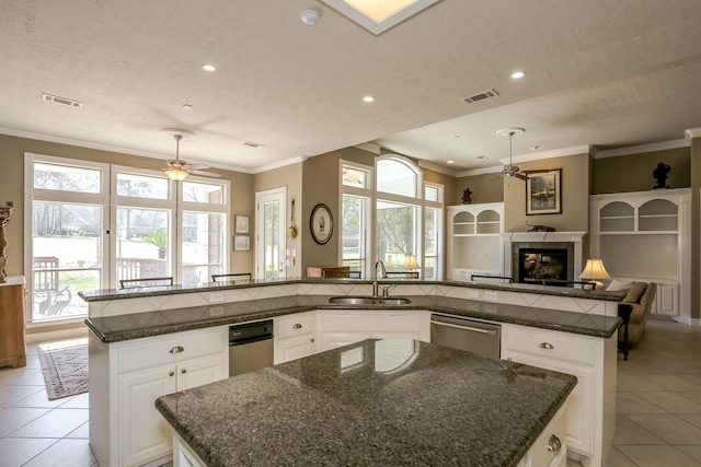 kitchen featuring visible vents, a spacious island, ceiling fan, a sink, and stainless steel dishwasher