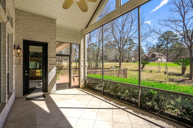 unfurnished sunroom featuring lofted ceiling, a healthy amount of sunlight, and ceiling fan