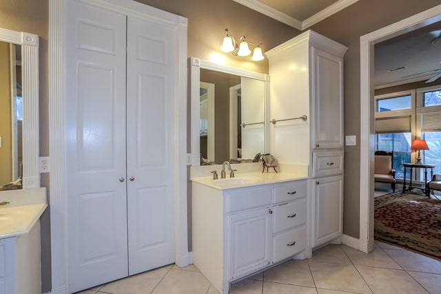 bathroom with tile patterned flooring, a sink, two vanities, visible vents, and crown molding