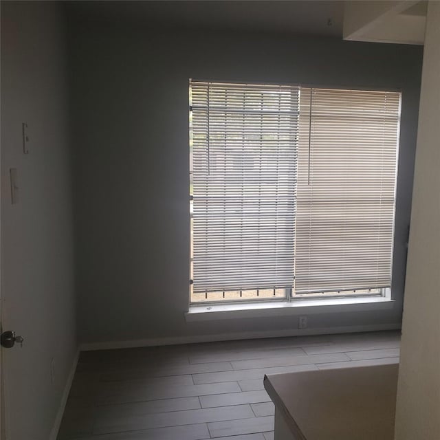 unfurnished room with baseboards