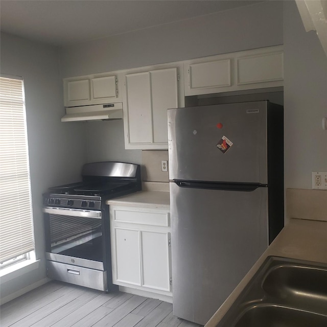 kitchen featuring stainless steel appliances, light countertops, white cabinetry, and under cabinet range hood