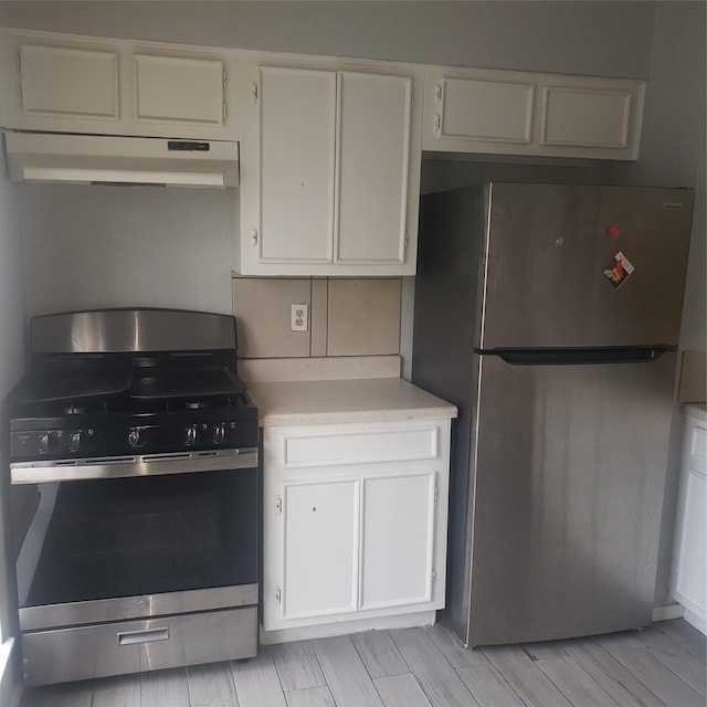 kitchen with light countertops, appliances with stainless steel finishes, white cabinetry, and under cabinet range hood