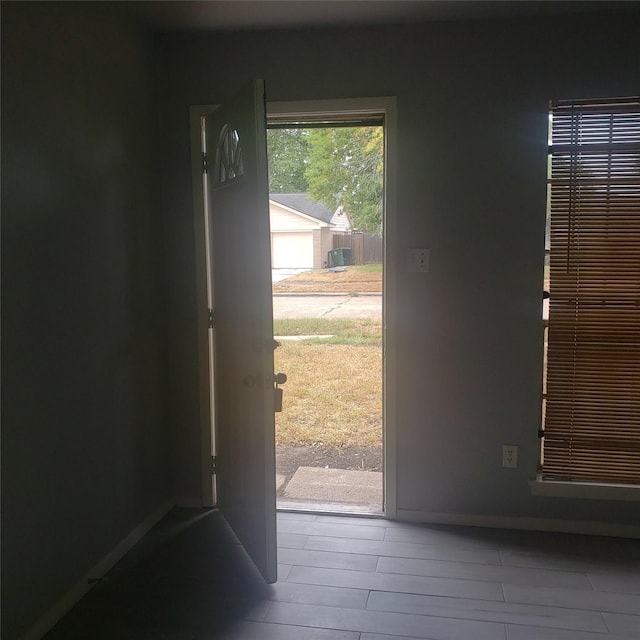 doorway to outside featuring baseboards