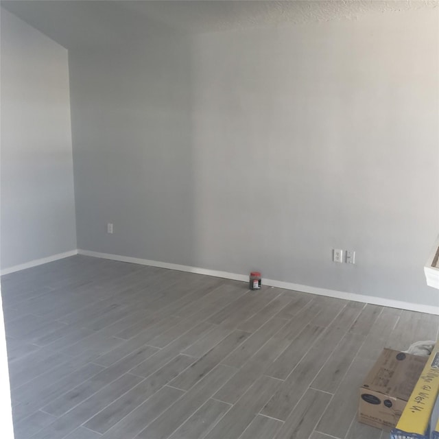 unfurnished room featuring baseboards and wood finished floors