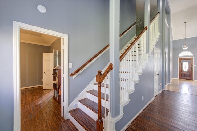 stairway with ornamental molding, baseboards, and wood finished floors