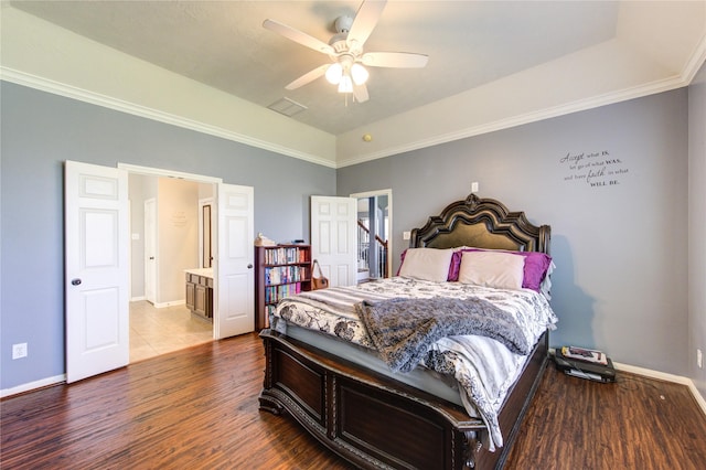 bedroom featuring ensuite bath, wood finished floors, visible vents, and baseboards