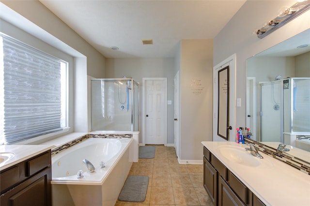 bathroom with a stall shower, vanity, a whirlpool tub, and tile patterned floors