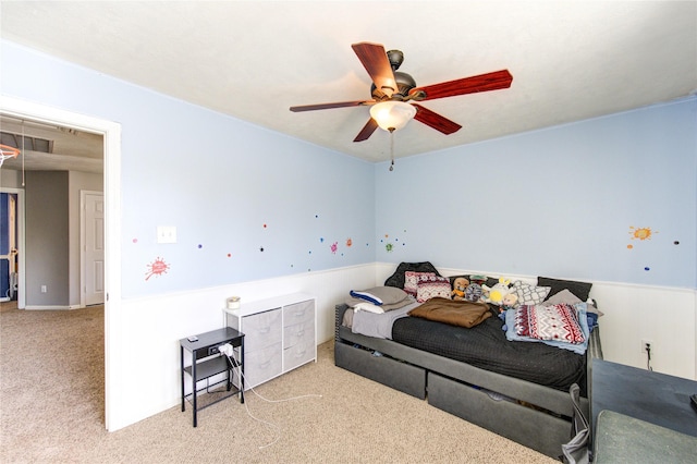 carpeted bedroom featuring attic access, visible vents, and a ceiling fan