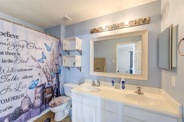 bathroom with double vanity, visible vents, toilet, and a sink