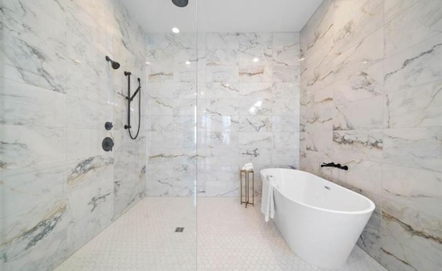 bathroom featuring a freestanding bath, a marble finish shower, and tile walls