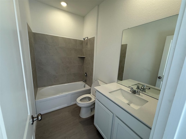 bathroom featuring toilet, shower / tub combination, wood finished floors, and vanity