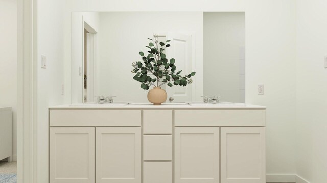 full bathroom with double vanity, baseboards, and a sink