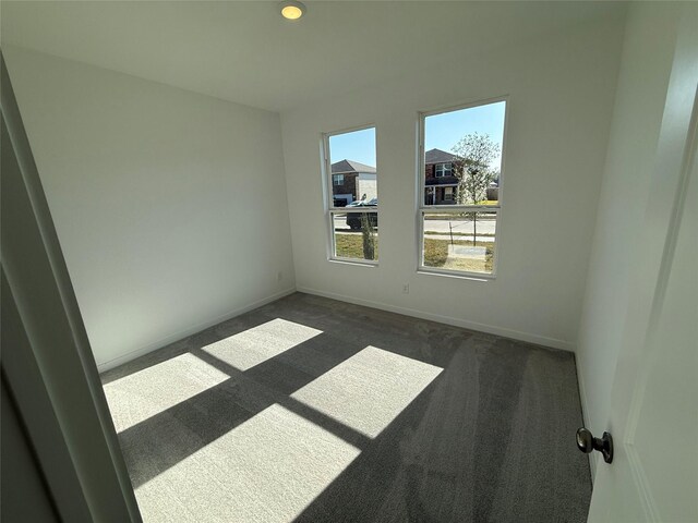 carpeted empty room featuring baseboards