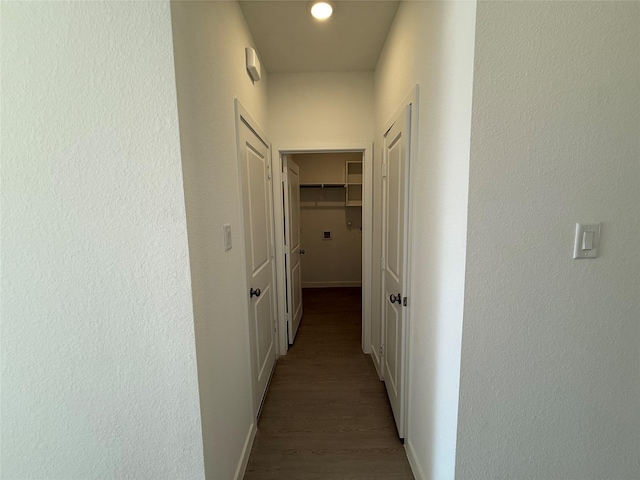 corridor featuring wood finished floors and baseboards