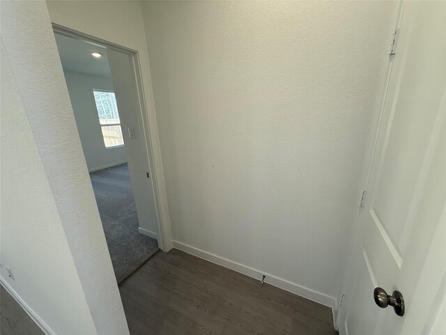 hall featuring dark wood-style floors and baseboards