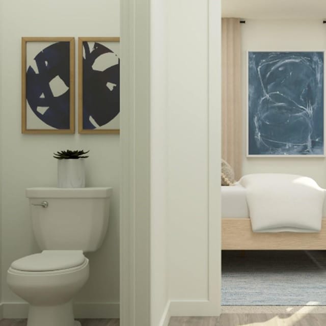 bathroom featuring toilet, baseboards, and wood finished floors