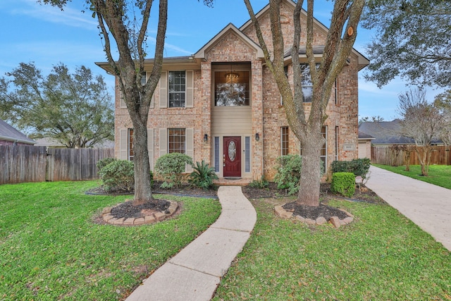 view of front of property featuring brick siding, a front yard, and fence