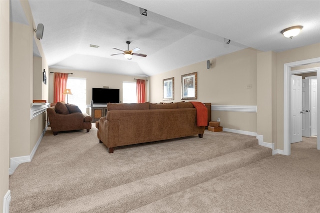 living area with a ceiling fan, carpet, lofted ceiling, and baseboards