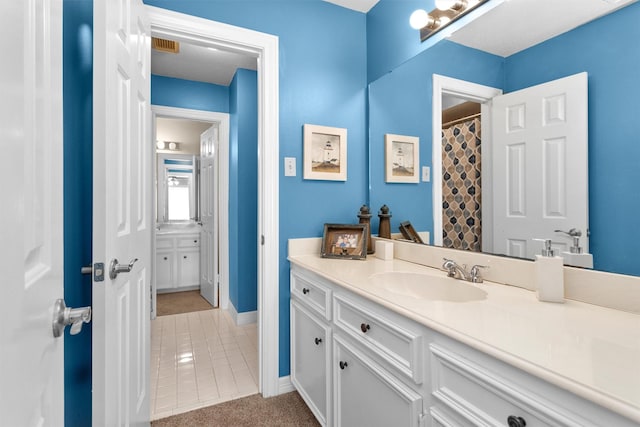 full bath with visible vents, baseboards, and vanity