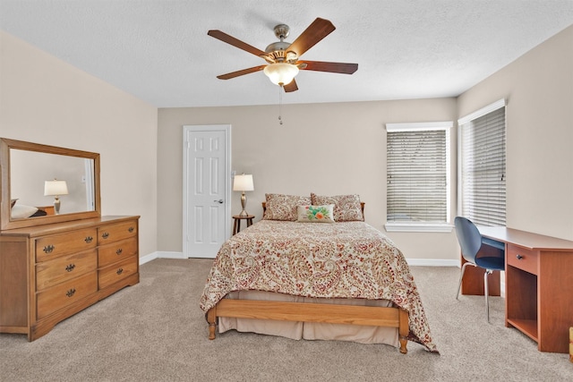 carpeted bedroom with a ceiling fan, a textured ceiling, and baseboards