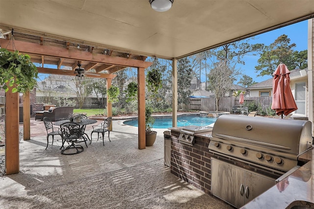 view of patio / terrace with a fenced backyard, grilling area, exterior kitchen, a pool with connected hot tub, and a pergola