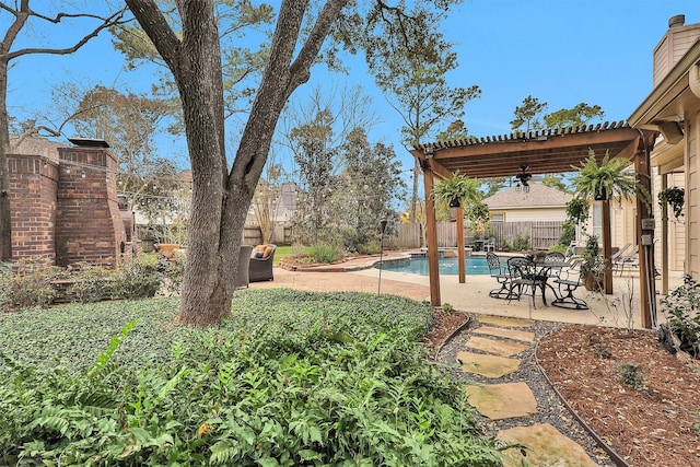 view of yard with a fenced in pool, a ceiling fan, a fenced backyard, a patio area, and a pergola