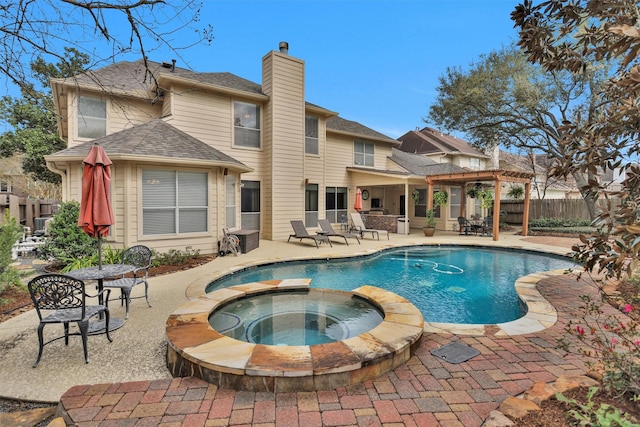 view of swimming pool featuring a patio area, a pool with connected hot tub, and fence